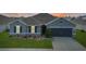 Charming single-story home featuring a well-manicured lawn and a two-car garage at 5767 Lakeside Landings Blvd, Winter Haven, FL 33881