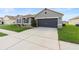 Single-story home with a well-maintained lawn, complemented by a two-car garage at 5767 Lakeside Landings Blvd, Winter Haven, FL 33881
