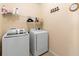 Functional laundry room with modern washer and dryer, and practical shelving at 5767 Lakeside Landings Blvd, Winter Haven, FL 33881