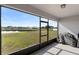 Screened in patio looking out onto a large yard, pond, and neighboring homes at 5767 Lakeside Landings Blvd, Winter Haven, FL 33881