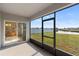 Screened in patio looking out onto a large yard, pond, and neighboring homes at 5767 Lakeside Landings Blvd, Winter Haven, FL 33881