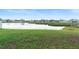 Beautiful pond view with a grassy shoreline in a residential neighborhood at 5767 Lakeside Landings Blvd, Winter Haven, FL 33881