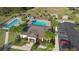 An aerial shot of a community pool with palm trees, lounge chairs, and a clubhouse at 5767 Lakeside Landings Blvd, Winter Haven, FL 33881