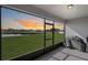 Comfortable screened-in patio with views of the lush backyard and a beautiful sunset at 5767 Lakeside Landings Blvd, Winter Haven, FL 33881