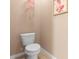 This small half-bathroom features a white toilet and neutral walls and trim at 5767 Lakeside Landings Blvd, Winter Haven, FL 33881