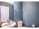 A light blue half bathroom featuring a toilet, sink, and silver towel rack at 578 Preserve Pointe Blvd, Davenport, FL 33837