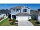 Two-story home with a manicured lawn, featuring blue siding, coordinated shutters, and a two-car garage at 578 Preserve Pointe Blvd, Davenport, FL 33837