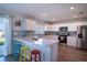 Modern kitchen with a breakfast bar, stainless steel appliances, and wood-look flooring at 578 Preserve Pointe Blvd, Davenport, FL 33837
