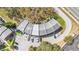Aerial of condominiums featuring assigned parking near a curved building and mature trees at 5850 Cypress Gardens Blvd # 206, Winter Haven, FL 33884