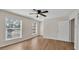 Bright bedroom featuring wood-look floors, two large windows, and a modern ceiling fan at 5850 Cypress Gardens Blvd # 206, Winter Haven, FL 33884