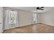 Spacious bedroom with wood flooring, ceiling fan, and two windows at 5850 Cypress Gardens Blvd # 206, Winter Haven, FL 33884