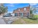 Rear view of brick townhouse featuring a screened patio and parking area at 5850 Cypress Gardens Blvd # 206, Winter Haven, FL 33884