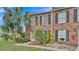 Charming brick townhomes featuring dark shutters, white doors, and small yard with palm trees at 5850 Cypress Gardens Blvd # 206, Winter Haven, FL 33884