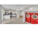 Kitchen with stainless steel appliances next to a laundry room with red washer and dryer units at 5850 Cypress Gardens Blvd # 206, Winter Haven, FL 33884