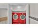 Laundry area featuring side-by-side, front-load red washer and dryer units at 5850 Cypress Gardens Blvd # 206, Winter Haven, FL 33884