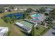 A beautiful aerial view of a community showcasing a large pond, pool, shuffleboard courts and lush landscaping at 6053 Southern Oaks Se Dr, Winter Haven, FL 33884