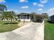 Well-maintained single-story home with a carport and a charming Florida room under a sunny blue sky at 6053 Southern Oaks Se Dr, Winter Haven, FL 33884