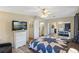 Spacious bedroom features a ceiling fan, ensuite bath, mirrored closet, and television for ultimate comfort at 6053 Southern Oaks Se Dr, Winter Haven, FL 33884