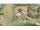 Top-down aerial view of a private property with a brown roof, surrounded by greenery and structures at 660 Duggers Way, Lake Wales, FL 33859