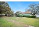 Back of the home features a screened porch with a large grassy yard at 660 Duggers Way, Lake Wales, FL 33859