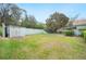 Spacious, grassy backyard with a block storage shed, mature trees, and partial house view at 660 Duggers Way, Lake Wales, FL 33859