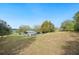 Expansive backyard with green grass, utility shed, and partial lake views, perfect for outdoor activities and relaxation at 660 Duggers Way, Lake Wales, FL 33859