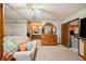 A main bedroom features a four poster bed with an en suite bathroom, seating, and a TV at 660 Duggers Way, Lake Wales, FL 33859
