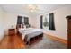 A bedroom features hardwood floors, a bed with neutral bedding, and black out curtains at 660 Duggers Way, Lake Wales, FL 33859
