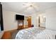A bedroom features hardwood floors, neutral bedding, a ceiling fan, and an attached bathroom at 660 Duggers Way, Lake Wales, FL 33859