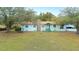Inviting one-story home with a stone chimney, covered porch, and mature trees at 660 Duggers Way, Lake Wales, FL 33859