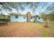 Charming front exterior view showcasing the stone chimney and mature trees at 660 Duggers Way, Lake Wales, FL 33859