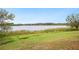 Scenic view of the lake with grassy shoreline, provides a tranquil setting and potential for waterside enjoyment at 660 Duggers Way, Lake Wales, FL 33859