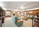 Expansive living room with a stone fireplace, wood paneling, and comfortable furnishings at 660 Duggers Way, Lake Wales, FL 33859