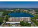 Scenic aerial view of the condo, lake, and surrounding neighborhood at 700 Mirror Nw Ter # 111, Winter Haven, FL 33881
