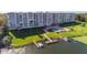 Waterfront condo complex featuring boat docks, a pool, and landscaped grounds at 700 Mirror Nw Ter # 111, Winter Haven, FL 33881