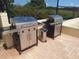 Outdoor community space featuring two stainless steel gas grills on a paved patio area at 700 Mirror Nw Ter # 111, Winter Haven, FL 33881