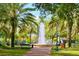 Exterior view of a park with a water fountain and many palm trees at 700 Mirror Nw Ter # 111, Winter Haven, FL 33881