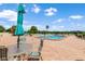 Outdoor pool on a brick patio with tables, chairs, and blue umbrellas at 700 Mirror Nw Ter # 111, Winter Haven, FL 33881
