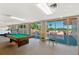 Large recreation room with a billiard table and patio access with water views at 700 Mirror Nw Ter # 111, Winter Haven, FL 33881