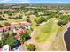 An aerial view of single Gathering homes in a golf community surrounded by lush greenery and mature trees at 7016 Village Dr, Lake Wales, FL 33898