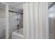 Bathroom boasting a shower-tub combo, neutral tile, and sleek shower curtain at 7016 Village Dr, Lake Wales, FL 33898
