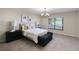 Well-lit bedroom with a black accent bench, comfortable bed, and scenic outdoor view at 7016 Village Dr, Lake Wales, FL 33898