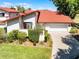Inviting villa with red tile roof, well-maintained landscaping, and a two-car garage with paved driveway at 7016 Village Dr, Lake Wales, FL 33898