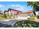 Attractive single-story home with a two-car garage, concrete driveway, and lush landscaping at 7016 Village Dr, Lake Wales, FL 33898