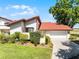 Charming home featuring a red tile roof, well-manicured lawn, and a two-car garage at 7016 Village Dr, Lake Wales, FL 33898