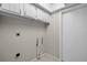 Laundry area has a wall with plumbing connections, tile flooring, white cabinets, and door, ready for appliances at 7016 Village Dr, Lake Wales, FL 33898