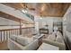 A loft-style living room with a ceiling fan, wood ceiling, and neutral decor providing a cozy and inviting space at 7016 Village Dr, Lake Wales, FL 33898