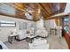 Spacious living room featuring wood-paneled ceilings, a ceiling fan, and neutral-colored furniture at 7016 Village Dr, Lake Wales, FL 33898