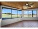 Tile-floored sunroom features a beautiful view of the green landscape through large windows and wood-paneled ceiling at 7016 Village Dr, Lake Wales, FL 33898