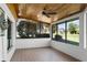 Bright, tiled sun room featuring wood ceilings and large windows offering a serene and relaxing retreat at 7016 Village Dr, Lake Wales, FL 33898